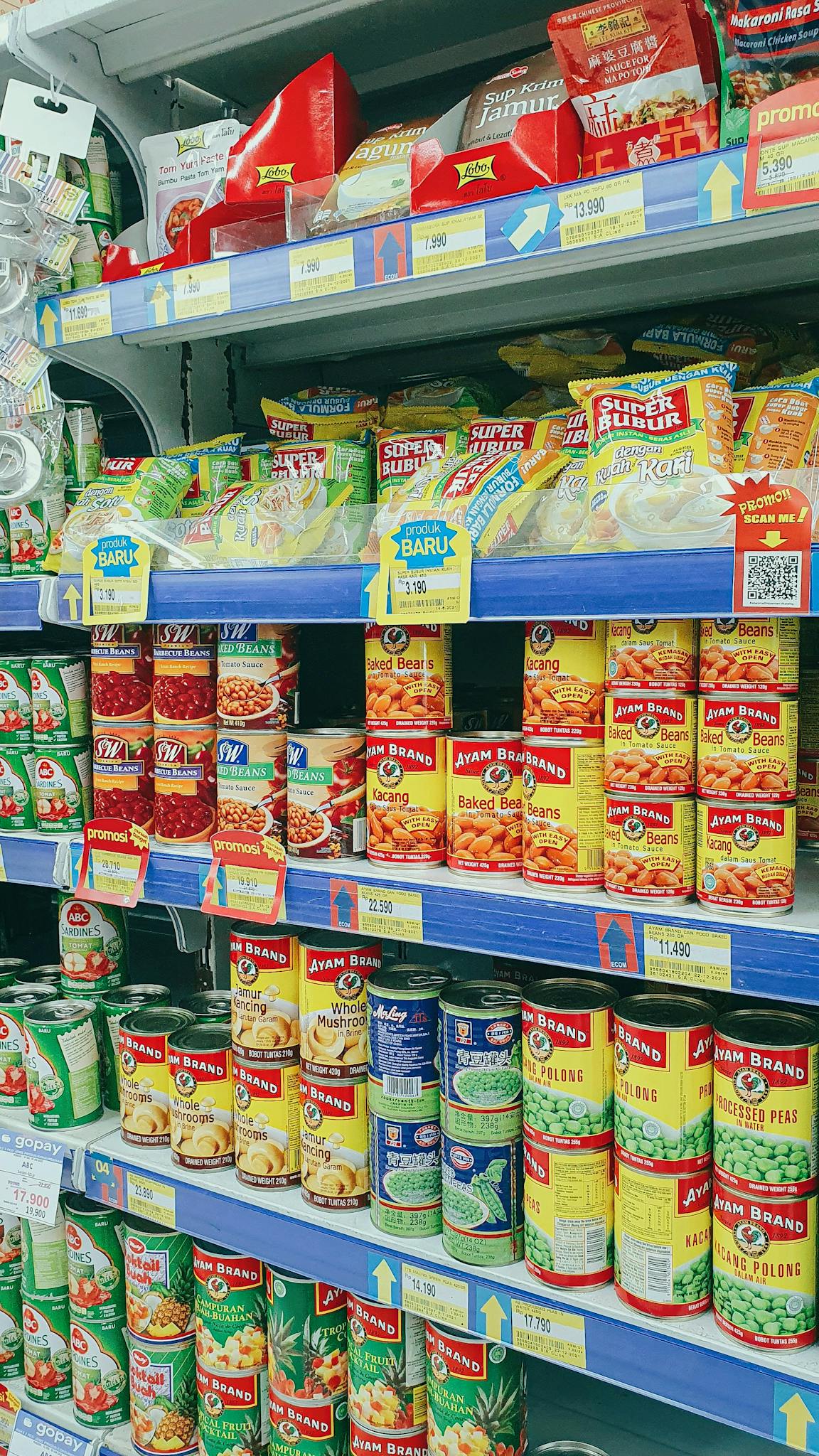 Canned and packaged goods neatly arranged on grocery store shelves, showcasing diverse food products.
